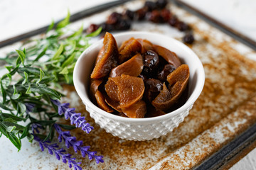 Sweet and soft dried Apple and rose hips prepared for dessert, decorated with a sprig of lavender and dry fruits on an unusual white and rusty metal background