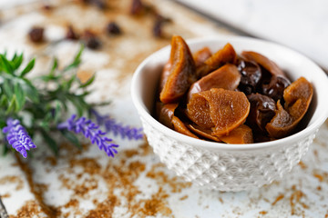 Sweet and soft dried Apple and rose hips prepared for dessert, decorated with a sprig of lavender and dry fruits on an unusual white and rusty metal background
