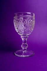 one empty glass on purple background in the middle