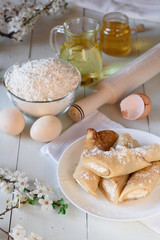 Pancakes with cottage cheese on a white wooden background. Shot with honey, sunflower seeds, flour and eggs. A traditional breakfast.