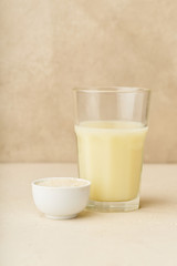 Dairy alternative. Rice milk in a glass on beige background. Healthy protein vegan drink.