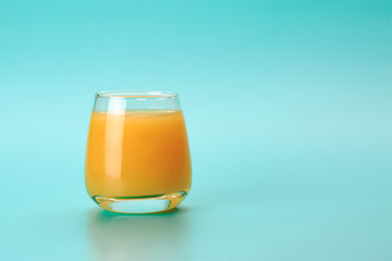 Orange juiceover blue background. Food supplement concept