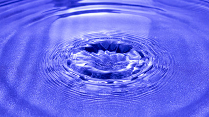 Drop of water falling and creating ripples.