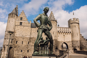 Fototapeta na wymiar Statue of Lange Wapper in front of the castle in Antwerpen. Lange Wapper is a legend about a giant who irritates people, children, drunkards, and loose women.