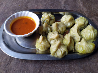 some fresh eatable food put in a plate with red chutney