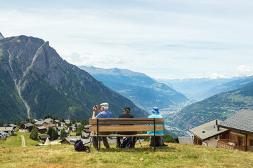 people on the bench, view of the valley in the mountains, switzerland, travel, trekking