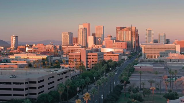 Aerial flying over downtown Phoenix city skyline at sunset. Phoenix, Arizona, USA. 