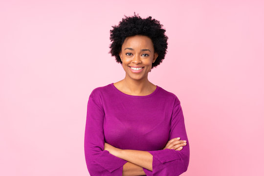 African american woman over isolated pink background keeping the arms crossed in frontal position
