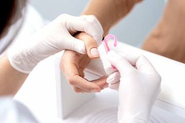 Manicure master removes dust from nails with a brush to cleaning nails.