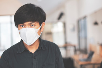 Fototapeta na wymiar Young male asia wearing face mask protect filter against air pollution (PM2.5) or wear N95 mask. protect pollution, anti smog and Covid 19 viruses, Air pollution health problem.