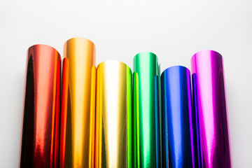 Bright shiny colorful foil in rolls on a white background