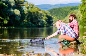 Sharing his secrets. Friends spend nice time at riverside. Beautiful evening riverside. Experienced...