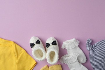 Flat lay composition with child's clothes on violet background, space for text