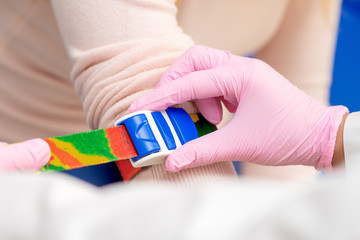 Nurse tightens the harness on the arm to take blood from a vein for analysis.