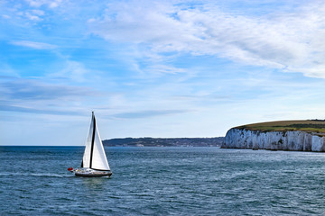 Sailing Yacht sailing in the English Channel off the white cliffs in calm water with blue sky and...