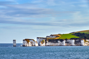 View of Old Harry Rocks with blue sky and some clouds. Calm sea on the approach to Poole Harbour...