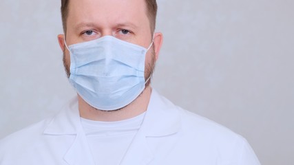 Male in a protective mask and a white shirt looks at the camera, close-up. Hygiene concept. prevent the spread of germs and bacteria and avoid infection with the crown virus. copy space