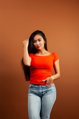 young pretty asian woman cheerful smiling posing on warm brown background, lifestyle people concept