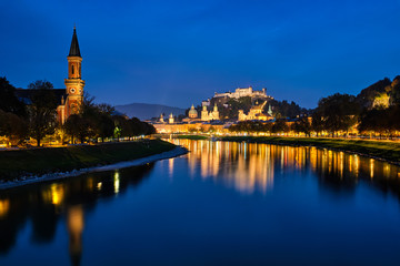 Naklejka premium Salzburg city evening view. Cathedral, Old Town Altstadt, Evangelische Pfarrgemeinde Christuskirche Hohensalzburg castle illuminated at night. Salzach River waterfront promenade. Salzburg, Austria