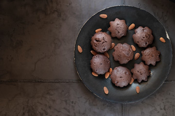 Dessert chocolate muffins on a black plate. Gray concrete background