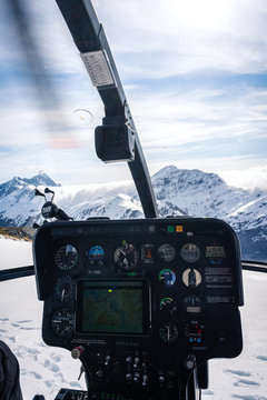 Stunning helicopter cockpit image with snowy Mount Aspiring in the background on a sunny winter day, New Zealand