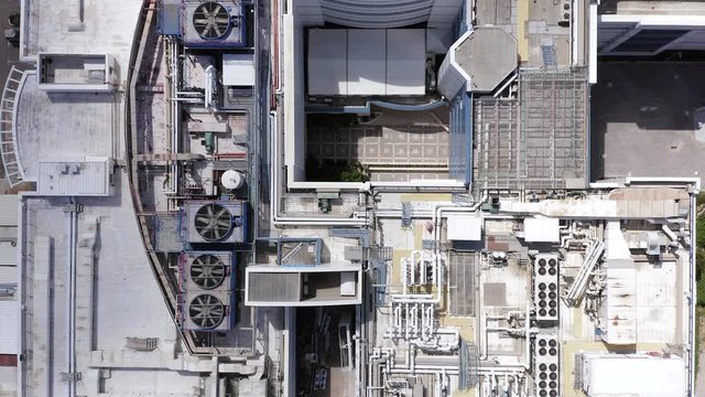 Aerial view of a large office building roof with various ventilation engine and systems running.
