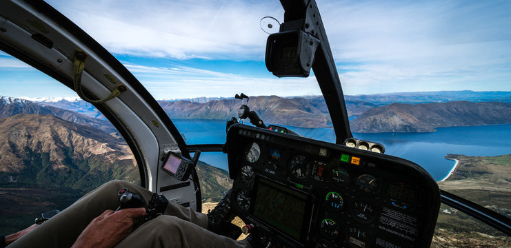 Stunning helicopter cockpit image with Wanaka lake in the background on a sunny winter day, New Zealand
