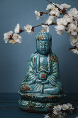 apricot branches and statue buddha on table
