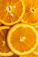 Bright orange background with slices of juicy oranges. Orange in the section. Orange-abstract fruit background, natural vitamins. Backgrounds and textures