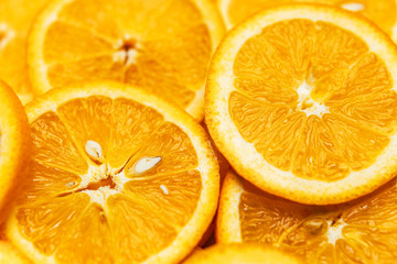 Bright orange background with slices of juicy oranges. Orange in the section. Orange-abstract fruit background, natural vitamins. Backgrounds and textures