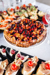 on a wooden table in the wedding banquet area are snacks, fruits, sweet cakes and muffins and lemonade drink