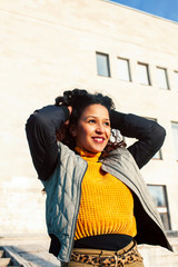 young pretty afican american girl happy smiling on city background, lifestyle people outside