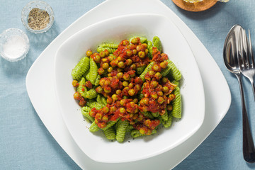 Italian fresh traditional sardinian pasta gnocchi with spinach and green pea tomato sauce. spring...