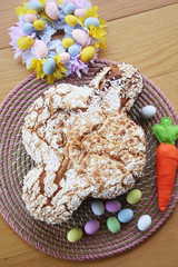Sweet Easter cake called Colomba Pasquale with Easter eggs and colorful decoration. Italian pastry on wooden table
