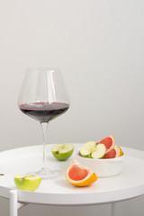 glass of red wine and fruits on the kitchen table
