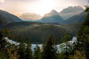 Obraz premium Blindsee in Tyrol, Austria during sunrise with lightbeams and mountains in the background