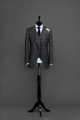 Atelier to repair clothes, Stylish look, Fashion look, Men look, Wedding style, Fashion concept, Brand clothing, Classic costume.Suit on black background. Store display. Classic style. Grey background