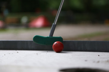 Detail Aufnahme vom Minigolf im Sommer mit einem Roten Ball auf Grauen Untergrund 
