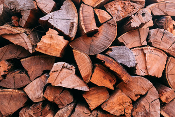 Close-up photo of firewood stacked into a neat pile. Firewood stacked ready for use in a fireplace in winter.