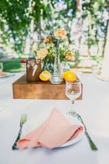 banquet table is decorated with plates, cutlery, glasses, candles and flower arrangements