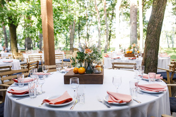 banquet table is decorated with plates, cutlery, glasses, candles and flower arrangements