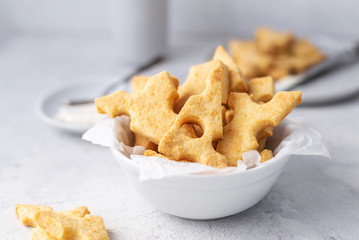 Cheese crackers, salty snack concept. Cookies, piece of cheese on a gray background