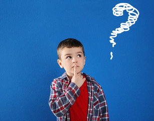 Emotional boy with drawing of question mark on blue background