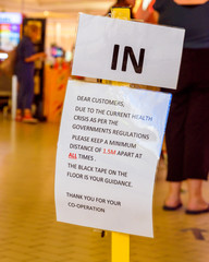 Signs in shopfronts indicating measures taken to stop the spread of Covid-19 including social distancing and closures