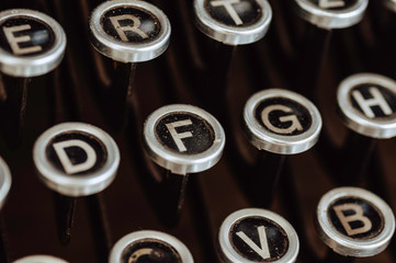 Close up English alphabet on keyboard of vintage retro typewriter, classic antique equipment for create and wording on paper.