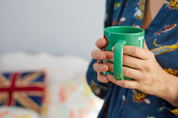 Mujer sujeta una taza de café verde.
