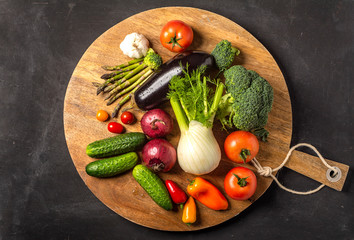 Exposition of fresh organic vegetables on wooden plate. tomato, pepper, broccoli, onion, garlic, cucumber,  eggplant, black Eyed Peas, ecological bag.