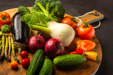 Exposition of fresh organic vegetables on wooden plate. tomato, pepper, broccoli, onion, garlic, cucumber,  eggplant, black Eyed Peas, ecological bag.