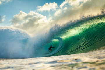 surfer riding a big barrelling wave at pipeline Hawaii - obrazy, fototapety, plakaty
