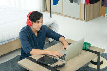  a young man is working at home and chatting with thousands of young people enjoying social news feeds on social media.
